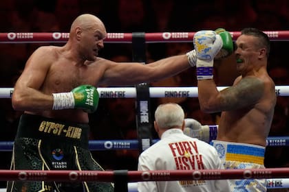 ARCHIVO - El británico Tyson Fury le aplica un golpe al ucraniano Oleksandr Usyk, en su combate por el título de los pesados, el 19 de mayo de 2024, en Riad