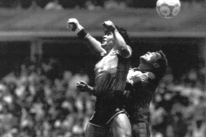 ARCHIVO - El delantero argentino Diego Maradona, izquierda, vence al guardameta inglés Peter Shilton para anotar el llamado gol de la “Mano de Dios” contra Inglaterra en duelo de los cuartos de final del Mundial de 1986, en Ciudad de México, el 22 de junio de 1986. (AP Foto/El Grafico, archivo)