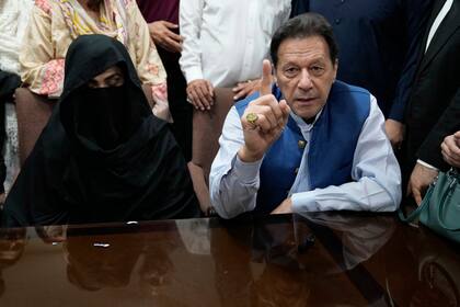 ARCHIVO - El exprimer ministro de Pakistán Imran Khan, y Bushra Bibi, su esposa, hablan con los medios en una oficina del Tribunal Superior de Lahore, en Pakistán, el 17 de julio de 2023. (AP Foto/K.M. Chaudary, Archivo)