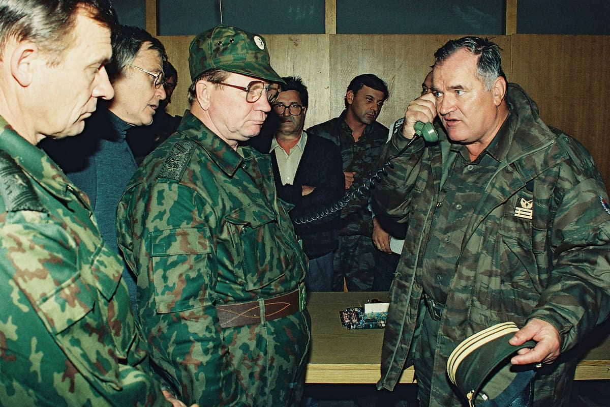 ARCHIVO - El general serbobosnio Ratko Mladic, derecha, habla por teléfono junto al general del ejér