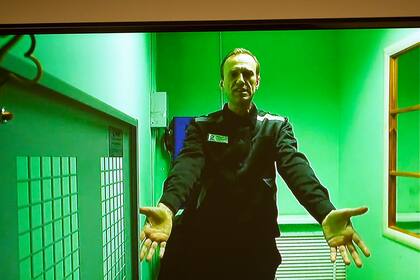 ARCHIVO - El líder de la oposición rusa Alexei Navalny es visto a través de una pantalla de TV en un enlace de video proporcionado por el Servicio Federal Ruso de Penitenciaría en una corte en Moscú, Rusia, el martes 18 de octubre de 2022. (AP Foto/Alexander Zemlianichenko, archivo)