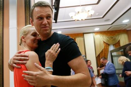 ARCHIVO - El líder opositor ruso Alexei Navalny, derecha, abraza a su esposa Yulia, al ser liberado por un tribunal en Kirov, Rusia, el viernes 19 de julio de 2013. (AP Foto/Dmitry Lovetsky, archivo)