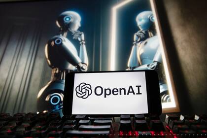 ARCHIVO - El logotipo de OpenAI aparece en un teléfono celular con una imagen en un monitor de computadora, generada por el modelo de texto a imagen Dali-E de ChatGPT, el viernes 8 de diciembre de 2023, en Boston. (AP Foto/Michael Dwyer, Archivo)