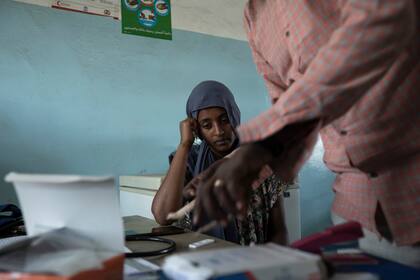 ARCHIVO - El médico y cirujano convertido en refugiado doctor Tewodros Tefera prepara una prueba de malaria para un refugiado de Tigray de 23 años, Hareg, de Mekele, Etiopía, en la clínica de la Media Luna Roja en Hamdayet, en el este de Sudán, cerca de la frontera con Etiopía, el 17 de marzo de 2021. (AP Foto/Nariman El-Mofty, Archivo)