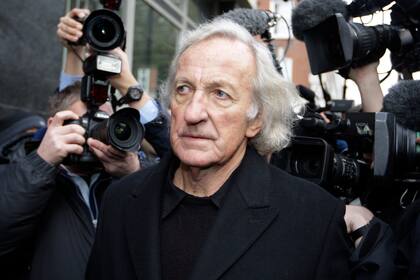 ARCHIVO - El periodista John Pilger, defensor del fundador de Wikileaks Julian Assange, llega a la corte de Westminster en Londres, para la audiencia de fianza de Assange, el martes 14 de diciembre de 2010. (AP Foto/Sang Tan, archivo)