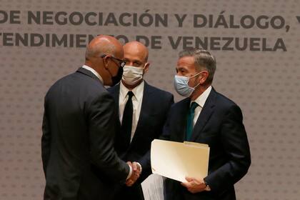ARCHIVO - El presidente de la Asamblea Nacional de Venezuela, Jorge Rodríguez, izquierda, le da la mano al delegado de la oposición venezolana, Gerardo Blyde Pérez, en la Ciudad de México, el 13 de agosto de 2021 en Barbados. (AP Foto/Marco Ugarte, Archivo)
