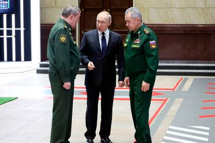 Archivo - El presidente ruso, Vladímir Putin (centro) habla con el jefe del Estado Mayor General, el general Valery Gerasimov (izquierda), mientras escucha el ministro de Defensa ruso, Sergei Shoigu, después de una reunión con oficiales militares de alto rango en Moscú, el 21 de diciembre de 2022. Putin ha guardado silencio sobre las duras críticas a la altos mandos militares lanzadas por Yevgeny Prigozhin, el millonario dueño del contratista militar privado ruso Grupo Wagner. (Mikhail Kuravlev, Sputnik, foto de Pool del Kremlin vía AP, Archivo)