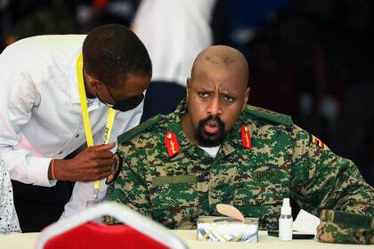 ARCHIVO - El teniente general Muhoozi Kainerugaba, hijo del presidente de Uganda, Yoweri Museveni, habla con el procurador general Kiryowa Kiwanuka, izquierda, en una ceremonia en Entebbe, Uganda, 7 de mayo de 2022. Museveni despidió a su hijo como comandante de las fuerzas de infantería el martes 4 de octubre de 2022 después que Kainerugaba tuiteó sin provocación una amenaza de tomar la capital de la vecina Kenia, lo que causó preocupación en todo el este de África. (AP Foto/Hajarah Nalwadda, File)