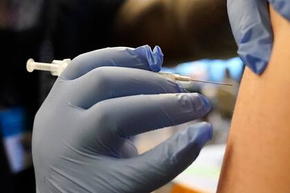 ARCHIVO - El trabajador médico DeMarcus Hicks aplica una vacuna contra el COVID-19 el 20 de diciembre de 2021, en la ciudad de Federal Way, estado de Washington. (AP Foto/Ted S. Warren, archivo)