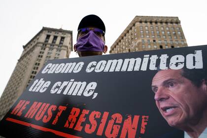 ARCHIVO _ En esta foto de 25 de marzo del 2021, un manifestante demanda la renuncia del entonces gobernador de Nueva York Andrew Cuomo por su manejo del brote de coronavirus en los hogares de ancianos.  (AP Foto/John Minchillo)