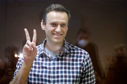 ARCHIVO - En esta foto de archivo del 20 de febrero de 2021, el líder opositor ruso Alexei Navalny hace un gesto desde la jaula de los acusados en la corte distrital Babuskinsky en Moscú, Rusia. La Unión Europea otorgó su máximo galardón en derechos humanos, el premio Sajarov, a Navalny el miércoles 20 de octubre de 2021. (AP Foto/Alexander Zemlianichenko, file)