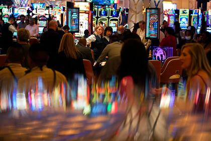 ARCHIVO - En esta foto de archivo del 24 de junio de 2021, se ven personas en el casino durante la noche de apertura del hotel-casino Resorts World Las Vegas en Las Vegas. (AP Foto/John Locher, Archivo)