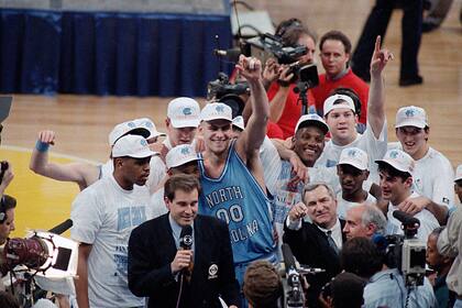 ARCHIVO - En esta foto de archivo del 5 de abril de 1993, Eric Montross (00), de North Carolina, alza el brazo mientras celebra la victoria contra Michigan en el juego de campeonato de la NCAA, en Nueva Orleans. Montross, quien brillara con North Carolina y en la NBA, falleció a los 52 años después de una batalla contra el cáncer. La Universidad emitió un comunicado el lunes 18 de diciembre de 2023, señalando que Montross murió el domingo rodeado de sus seres queridos en su casa en Chapel Hill. Fue diagnosticado con cáncer en marzo. (AP Foto/Bob Jordan, Archivo)