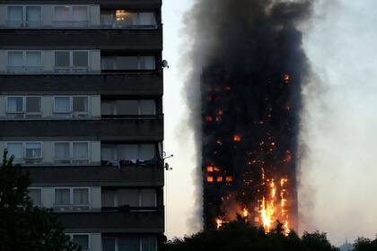ARCHIVO - En esta foto de archivo del miércoles 14 de junio de 2017, humo y llamas se elevan desde el rascacielos Grenfell Tower, en el oeste de Londres. (AP Foto/Matt Dunham, Archivo)