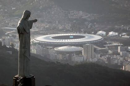 ARCHIVO - En esta foto del 13 de mayo de 2014, vista del estadio Maracaná detrás del Cristo Redentor en Río de Janeiro. Brasil será la sede de la Copa América por segunda edición seguida. (AP Foto/Felipe Dana, archivo)