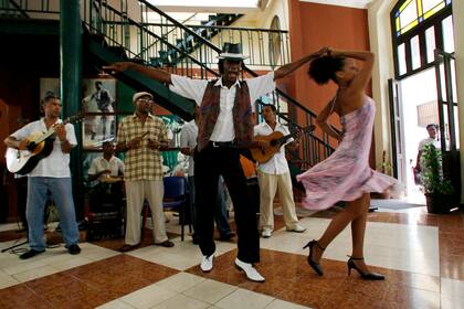 ARCHIVO - En esta foto del 22 de agosto de 2009, bailarines bailan una canción de bolero en el Café Taberna Amigos del Benny, en referencia al famoso músico cubano Benny Moré, en La Habana. Cuba declaró el bolero patrimonio inmaterial de la nación el martes 24 de agosto de 2021. (AP Foto/Franklin Reyes, Archivo)