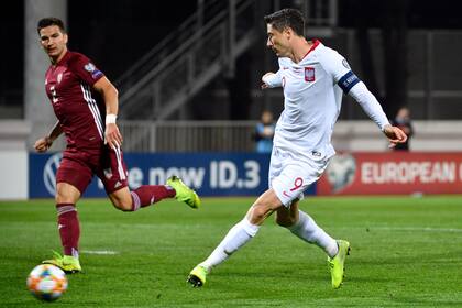 ARCHIVO - En esta foto del jueves 10 de octubre de 2019, Robert Lewandowski anota un gol para Polonia contra Letonia en un partido de las eliminatorias de la Eurocopa, en Riga. (AP Foto/Roman Koksarov, File)