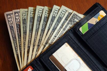 ARCHIVO - En esta fotografía de archivo del 15 de junio de 2018 pueden verse diversos billetes en una cartera en North Andover, Massachusetts. (AP Foto/Elise Amendola, archivo)