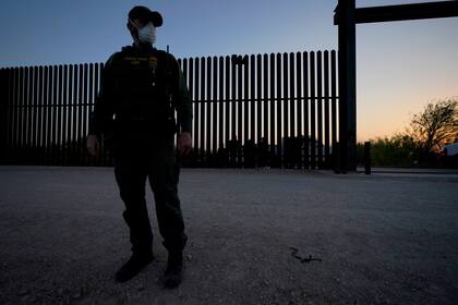 ARCHIVO - En esta fotografía de archivo del 21 de marzo de 2021, un agente de la Oficina de Aduanas y Protección Fronteriza monta guardia cerca de una puerta en el muro en la frontera entre México y Estados Unidos durante un operativo de detención de migrantes, en Abram-Perezville, Texas. (AP Foto/Julio Cortez, archivo)