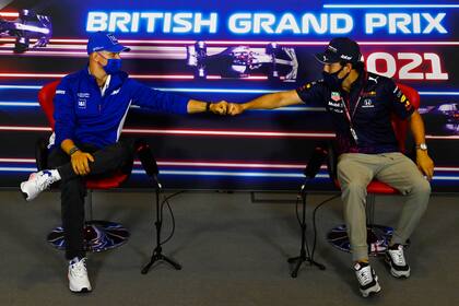 ARCHIVO - En esta fotografía del 15 de julio de 2021, el piloto Mick Schumacher (izquierda) y el piloto Sergio Pérez chocan los puños durante una conferencia de prensa en Silverstone, Inglaterra. (Mark Sutton, Pool Photo vía AP, Archivo)