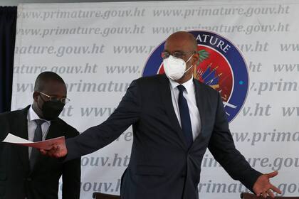 ARCHIVO - En esta fotografía del 20 de julio de 2021, el primer ministro de Haití, Ariel Henry, abre los brazos durante una ceremonia en Puerto Príncipe. (AP Foto/Joseph Odelyn, archivo)