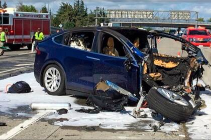 ARCHIVO - En esta fotografía del 23 de marzo de 2018 unos trabajadores de emergencias trabajan en la escena donde un vehículo Tesla chocó contra un muro en una autopista en Mountain View, California. (KTVU-TV vía AP, Archivo)