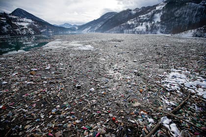 ARCHIVO - En esta fotografía del viernes 22 de enero de 2021, botellas de plástico y otros desechos flotan en el lago Potpecko, en Serbia. (AP Foto/Darko Vojinovic/Archivo)