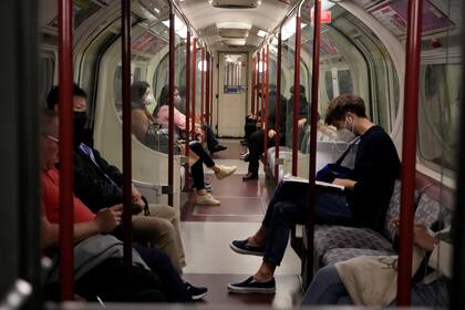 ARCHIVO - En esta imagen de archivo del 4 de octubre de 2021, gente viajando en el metro con mascarillas para combatir los contagios de coronavirus, en la línea Bakerloo del metro de Londres, Gran Bretaña. (AP Foto/Matt Dunham, archivo)