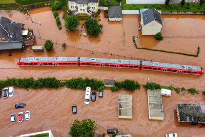 ARCHIVO - En esta imagen de archivo del jueves 15 de julio de 2021, un tren regional en medio de una inundación en la estación local de Kordel, Alemania, inundada por las crecidas del río Kyll. (Sebastian Schmitt/dpa vía AP, Archivo)