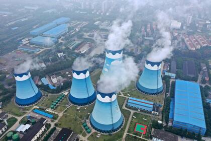 ARCHIVO - En esta imagen del 27 de septiembre de 2021, vapor saliendo de las torres de refrigeración en una central eléctrica de carbón en Nanjing, en la provincia oriental china de Jiangsu.  El mundo está inmerso en una crisis energéticas. Europa está sufriendo la peor parte, con precios del gas natural multiplicados por cinco, lo que ha obligado a algunas fábricas a detener la producción. (Chinatopix via AP, archivo)