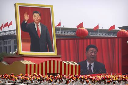 ARCHIVO - En esta imagen del martes 1 de octubre de 2019, participantes vitorean bajo un gran retrato del presidente de China, Xi Jinping, durante un desfile por el 70mo aniversario de la fundación del Partido Comunista Chino, en Beijing. (AP Foto/Mark Schiefelbein, Archivo)