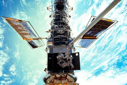 ARCHIVO - En esta imagen provista por NASA/JSC, los astronautas Steven L. Smith y John M. Grunsfeld realizan trabajos de mantenimiento del Telescopio Espacial Hubble en diciembre de 1999. El Hubble estará funcionando de nuevo pronto, luego de una difícil reparación remota por la NASA, se anunció el 16 de julio del 2021. (NASA/JSC via AP)