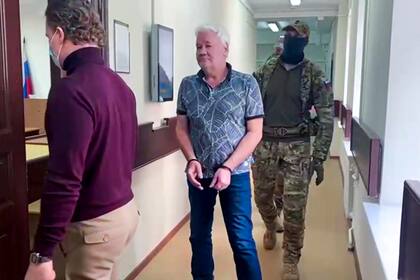 ARCHIVO - En esta imagen tomada de un video publicado por la Corte de Distrito de Lefortovo, Robert Shonov, ciudadano ruso que trabajó más de 25 años en el ahora clausurado consulado de Estados Unidos en Vladivostok, es escoltado por funcionarios a la sala en la Corte de Distrito de Lefortovo en Moscú, Rusia, el jueves 18 de mayo de 2023. (Corte del Distrito de Lefortovo via AP, Archivo)