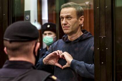 ARCHIVO - En imagen tomada de un video proporcionado por la Corte Municipal de Moscú el miércoles 3 de febrero de 2021, el líder opositor Alexei Navalny hace un gesto con sus manos desde una jaula durante una audiencia en Moscú, Rusia. (Corte Municipal de Moscú vía AP, archivo)