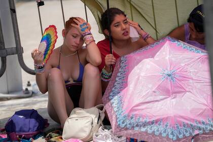 ARCHIVO - Fans de Taylor Swift aguardan para ingresar al estadio olímpico Nilton Santos en medio de una ola de calor en Río de Janeiro, 18 de noviembre de 2023. Una ola de calor sofocante reinaba en el sureste de Brasil el día del concierto de Swift. (AP Foto/Silvia Izquierdo, File)