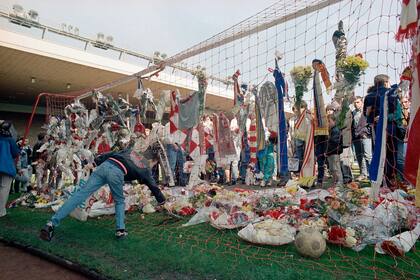 ARCHIVO - Foto del 16 de abril de 1989 aficionados del Liverpool colocan un par de zapatos en la portería en el Estadio de Anfield tras el incidente que cobró la vida de 97 aficionados en el estadio de Hillsborough. (AP Foto/Peter Kemp, Archivo)