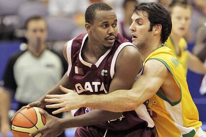 ARCHIVO - Foto del 24 de agosto del 2006, el jugador de la selección de Qatar Hashim Zaidan frente al australiano Sam Mackinnon en acciones durante el Mundial de Baloncesto en Hamamatsu, Japón. El viernes 28 de abril del 2023, FIBA elige a Qatar como sede la edición 2027 del Mundial. (AP Foto/David Longstreath, Archivo)
