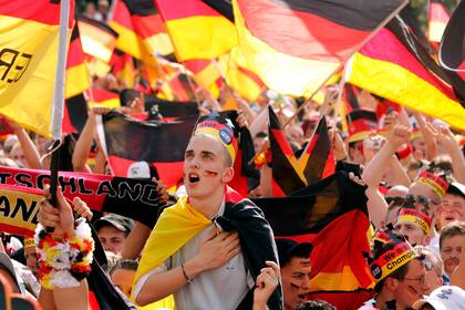 ARCHIVO - Foto del 24 de junio del 2006, aficionados alemanes cantan el himno nacional de Alemania antes del encuentro de octavos de final de la Copa Mundial ante Suecia en un evento público para ver el partido en Munich. (AP Foto/Franka Bruns, Archivo)