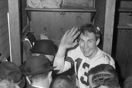 ARCHIVO - Foto del 27 de diciembre de 1964, el quarterback de los Browns de Cleveland Frank Ryan hace un gesto a la cámara mientras habla con reporteros tras superar a los Colts de Indianápolis por el título. El martes 2 de enero del 2024 anuncian el fallecimiento de Frank Ryan. (AP Foto/Archivo)