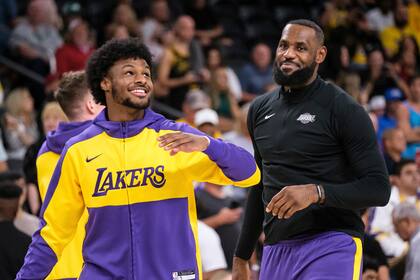 ARCHIVO - Foto del domingo 6 de octubre del 2024, el base de los Lakers de Los Ángeles Bronny James y el alero LeBron James calientan antes de un encuentro de pretemporada ante los Suns de Phoenix. (AP Foto/William Liang, Archivo)
