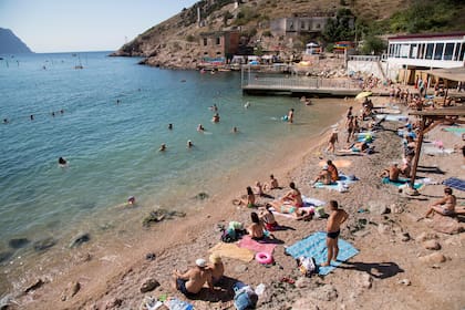 ARCHIVO - Gente pasa un día de playa en la bahía de Balaklava, península de Crimea, 9 de agosto de 2015. La península de Crimea ha sido un patio de juegos y un campo de batalla durante siglos. (AP Foto, File)