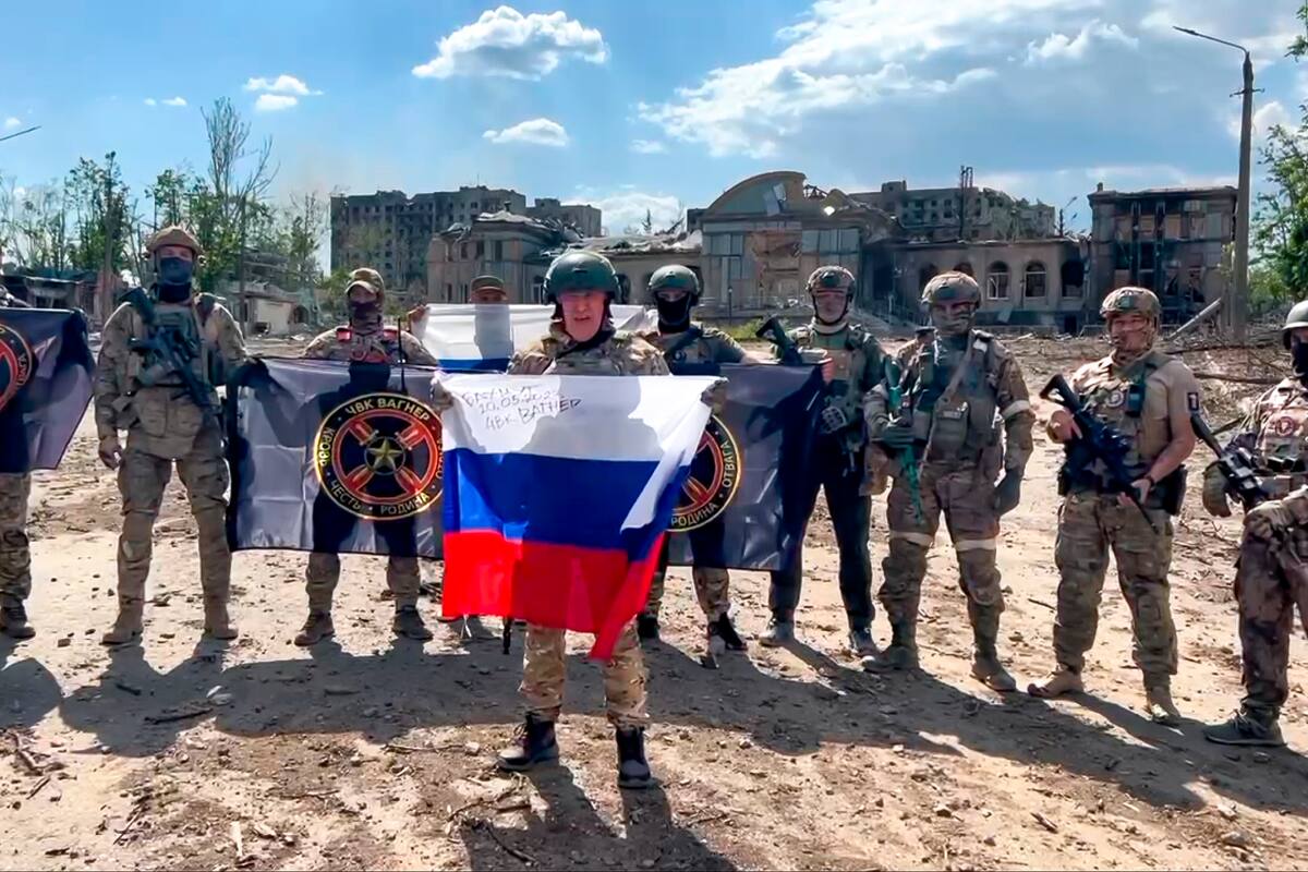 Archivo - Imagen tomada de un video y publicada el 20 de mayo de 2023 por el servicio de prensa de Yevgeny Prigozhin, jefe del contratista militar privado ruso Grupo Wagner, en la que él (al centro) habla mientras sostiene una bandera rusa frente a sus soldados en Bakhmut, Ucrania. (Servicio de Prensa de Prigozhin vía AP, Archivo)