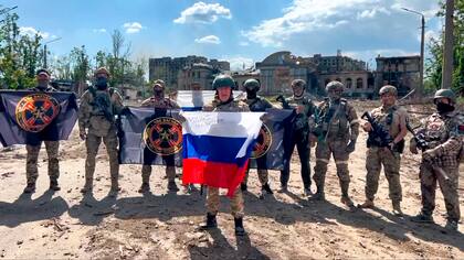 Archivo - Imagen tomada de un video y publicada el 20 de mayo de 2023 por el servicio de prensa de Yevgeny Prigozhin, jefe del contratista militar privado ruso Grupo Wagner, en la que él (al centro) habla mientras sostiene una bandera rusa frente a sus soldados en Bakhmut, Ucrania. (Servicio de Prensa de Prigozhin vía AP, Archivo)
