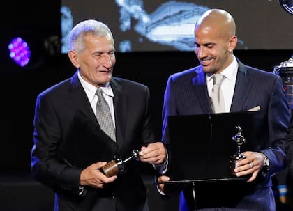ARCHIVO - Juan Ramón Verón y su hijo Sebastián reciben un homenaje durante la ceremonia del sorteo de la Copa Libertadores, el 2 de diciembre de 2014, en Luque, Paraguay (AP Photo/Jorge Saenz, archivo)