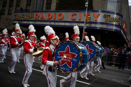 ARCHIVO -  Juerguistas recorren la Avenida de las Américas frente al Radio City Music Hall durante el Desfile de Macy's del Día de Acción de Gracias, el 28 de noviembre de 2019 en Nueva York. (AP Foto/Eduardo Munoz Alvarez, Archivo)