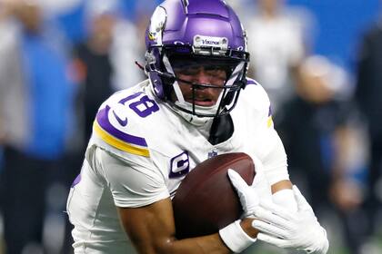 ARCHIVO - Justin Jefferson, wide receiver de los Vikings de Minnesota, lleva el balón en contra de los Lions de Detroit durante la primera mitad del juego de la NFL, el 7 de enero de 2024, en Detroit. Los Vikings y Jefferson pactaron una extensión de contrato por cuatro años, el más rico para un jugador que no es QB. (AP Foto/Duane Burleson, Archivo)