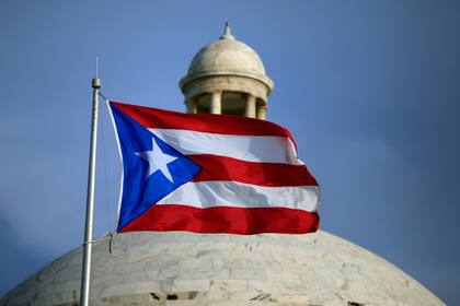 Archivo - La bandera puertorriqueña ondea delante del Capitolio de Puerto Rico el 29 de julio de 2015, en San Juan. (AP Foto/Ricardo Arduengo, Archivo)