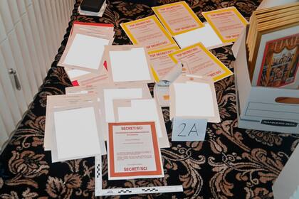 ARCHIVO - La imagen contenida en una carpeta judicial del Departamento de Justicia el 30 de agosto de 2022 y parcialmente tapada por la fuente muestra una foto de documentos incautados por el FBI en la finca de Mar-a-Lago del expresidente Donald Trump. (Departamento de Justicia via AP, File)