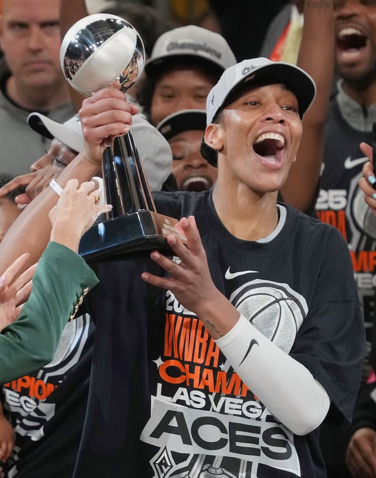 ARCHIVO - La jugadora de Las Vegas Aces A'ja Wilson, en el centro a la derecha sostiene su trofeo a la Jugadora Más Valiosa tras el cuarto juego de las finales de la WNBA contra las Mercury de Phoenix, el viernes 10 de octubre de 2025, en Phoenix. (AP Foto/Rick Scuteri, Archivo)