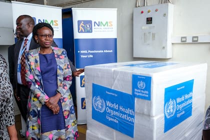 ARCHIVO - La ministra ugandesa de Salud, Jane Ruth Aceng, recibe cajas con una de las tres candidatas a vacuna contra la cepa de Sudán del virus del ébola, en Entebbe, Uganda, el 8 de diciembre de 2022. Según el Ministerio de Salud de Uganda, el país ha recibido 1.200 dosis de vacunas de la OMS para combatir un nuevo ensayo de vacuna contra el ébola. (AP Foto/Hajarah Nalwadda, Archivo)
